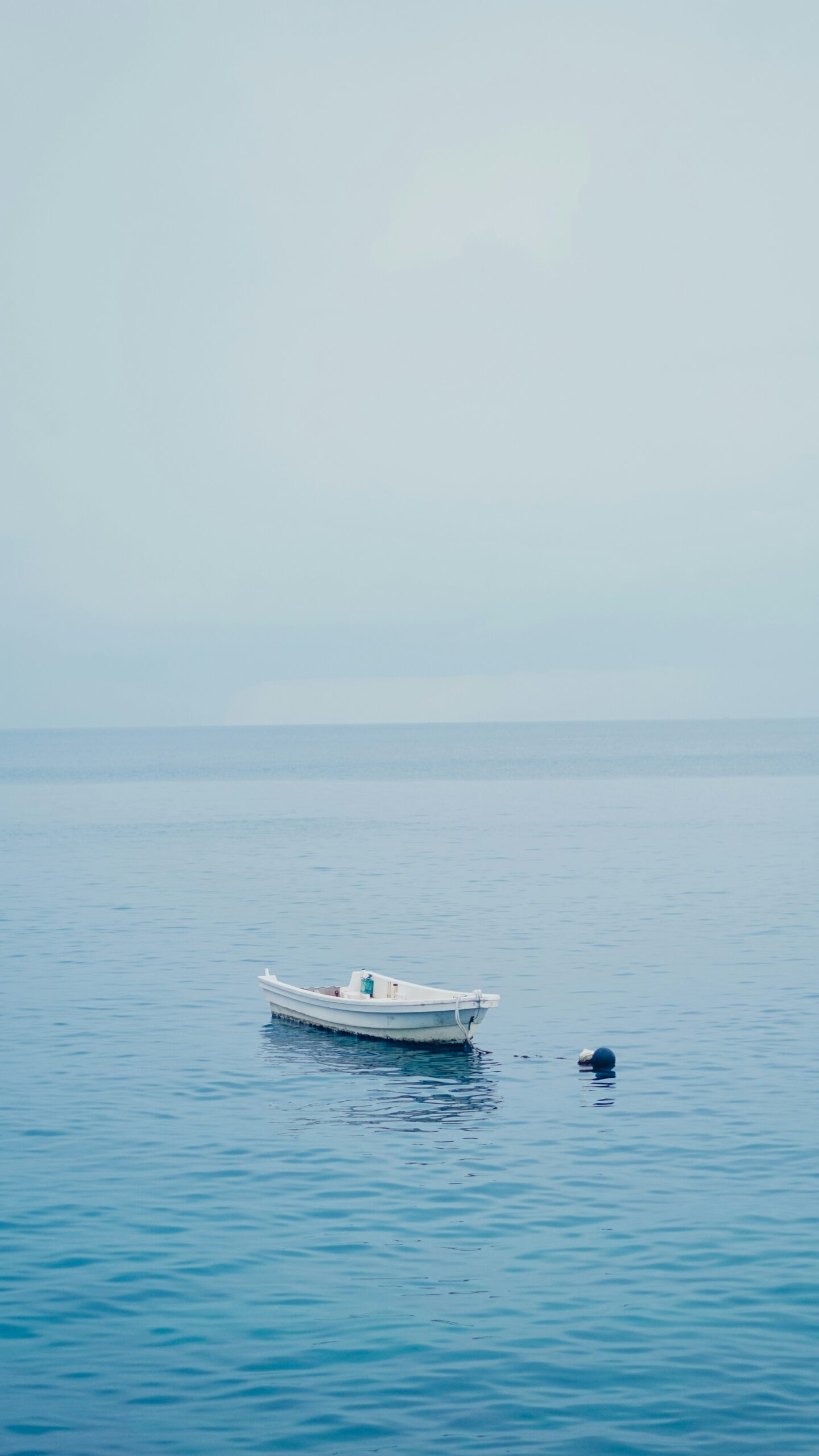 a small boat floating on top of a large body of water